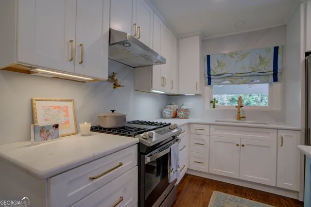 a kitchen with cabinets appliances a sink and a window