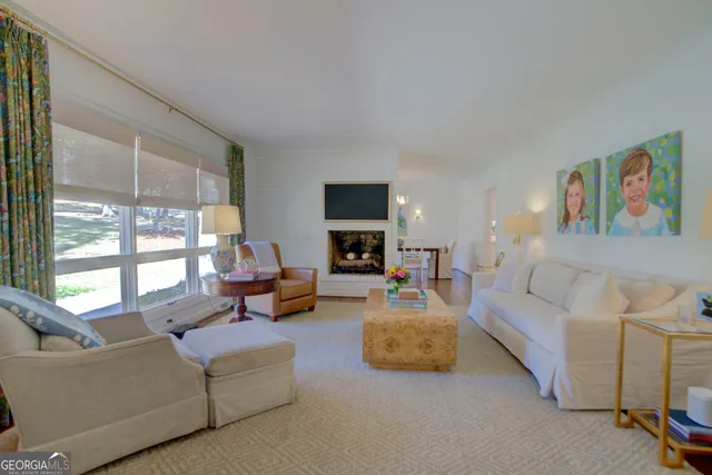a living room with furniture fireplace and a large window