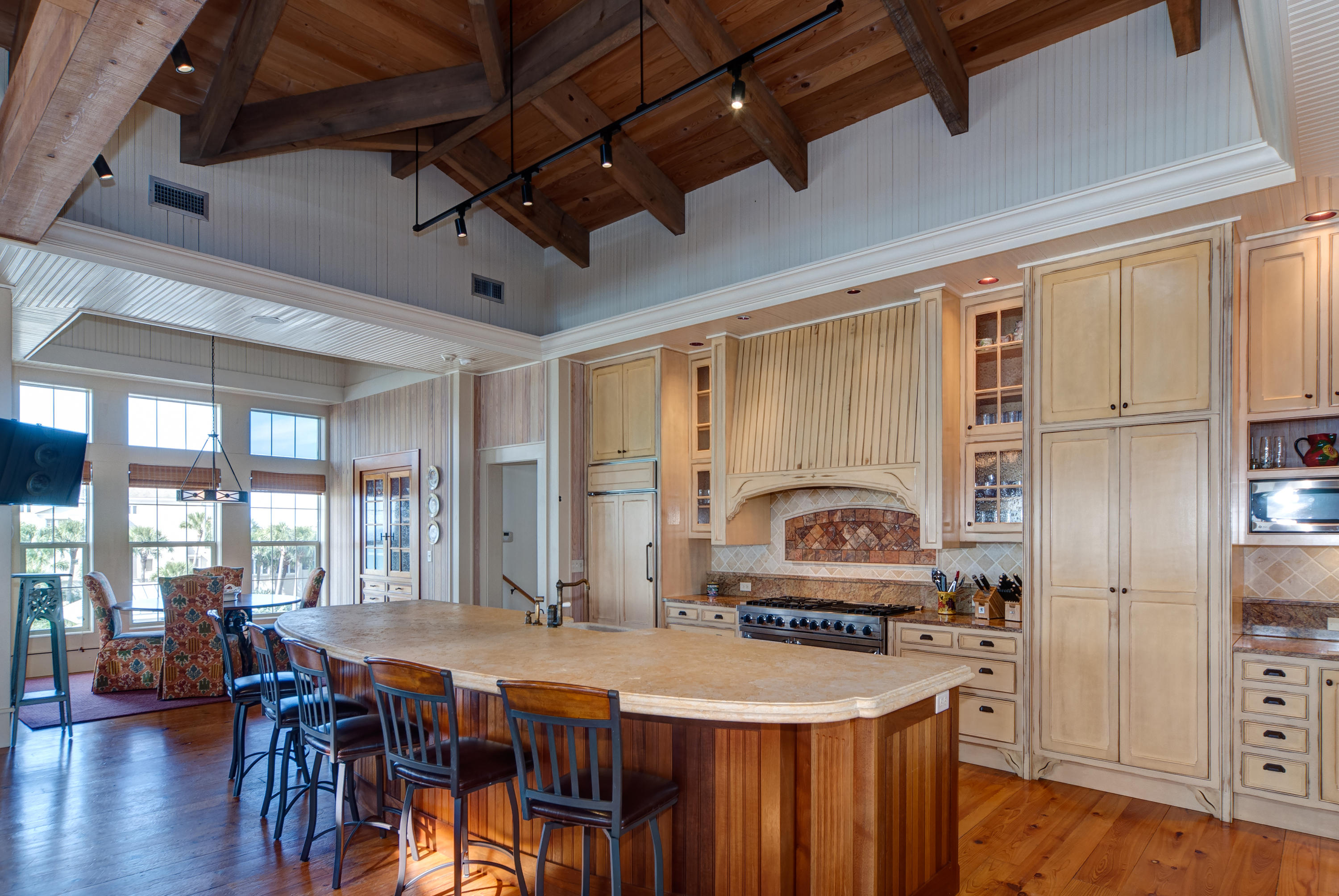 491 Old Beach Road Santa Rosa Beach, FL 32459 - Photo 10 of 36 a kitchen with stainless steel appliances granite countertop a stove a refrigerator a dining table and chairs with wooden floor