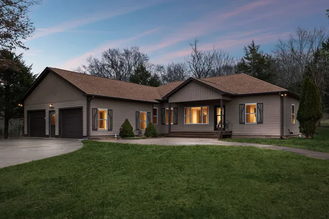 a front view of a house with a yard and trees