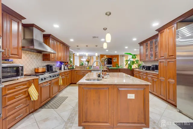 a kitchen with stainless steel appliances granite countertop a sink and a refrigerator