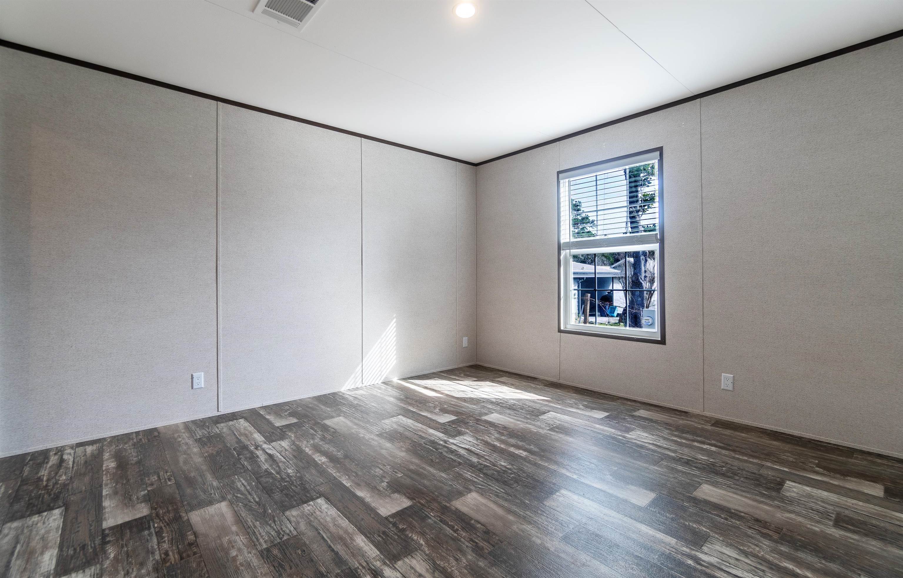 102 Pinelake Drive Satsuma, FL 32189 - Photo 16 of 35 wooden floor in an empty room with a window