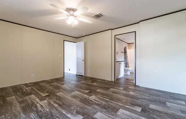 a view of a big room with wooden floor and a ceiling fan