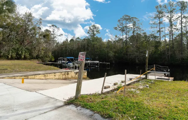 a view of house with a big yard and potted plants