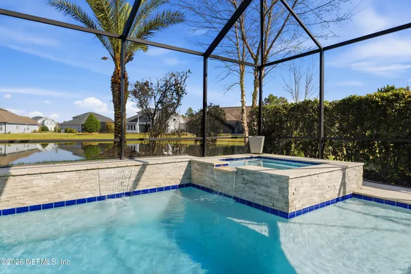 a large white kitchen with stainless steel appliances kitchen island granite countertop a lot of counter space and a sink