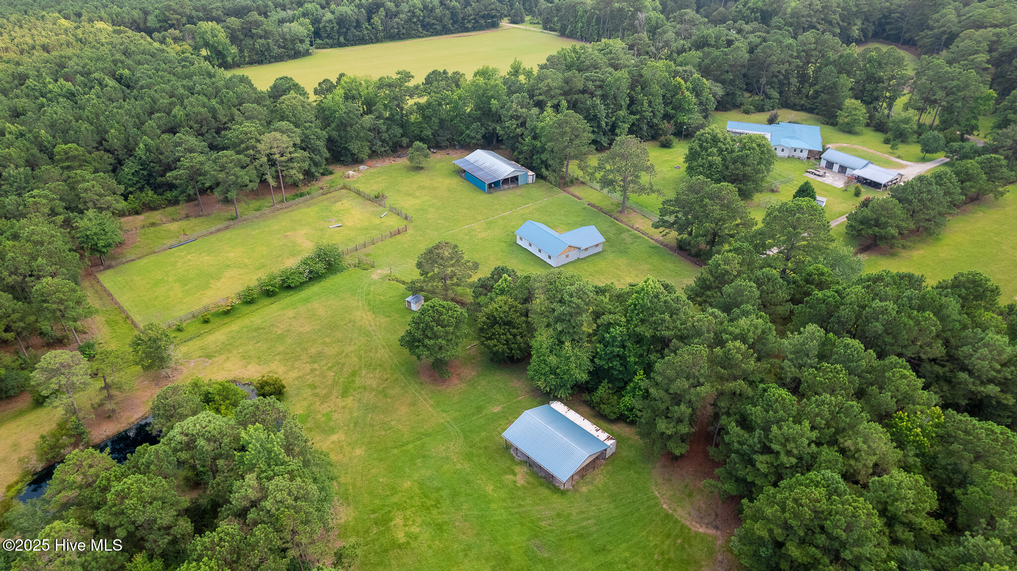 Residence and garage in upper right, Pole Barn #1 at top of middle, Stable in center, Pole Barn #2 in bottom of middle, training paddock in upper left.