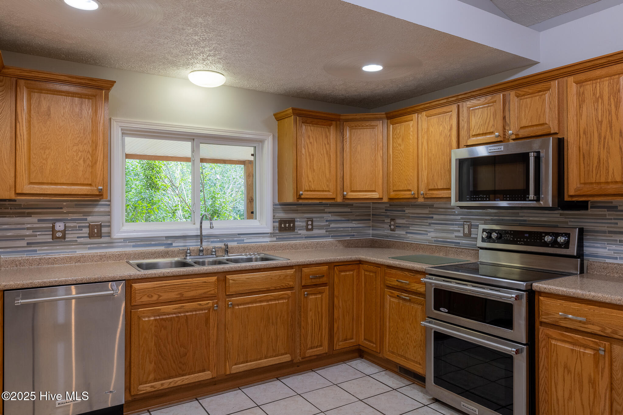 161 Howard Lane Swansboro, NC 28584 - Photo 12 of 56 Kitchen sink window looks out over wrap around porch and into side yard.