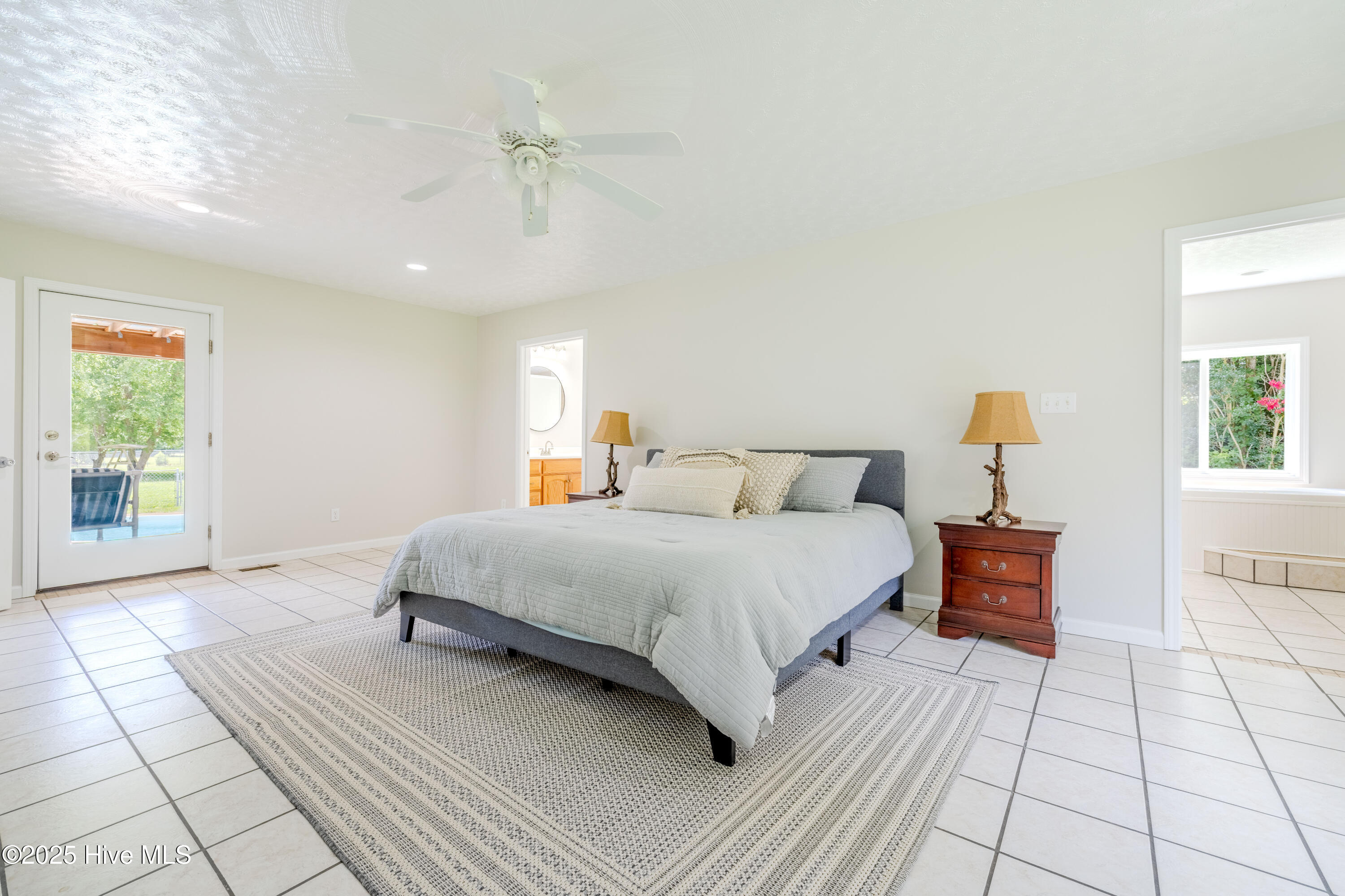 161 Howard Lane Swansboro, NC 28584 - Photo 47 of 56 Airy primary suite looks out over back porch and onto pool. Doors on either side of bed open to his and her bath suite.