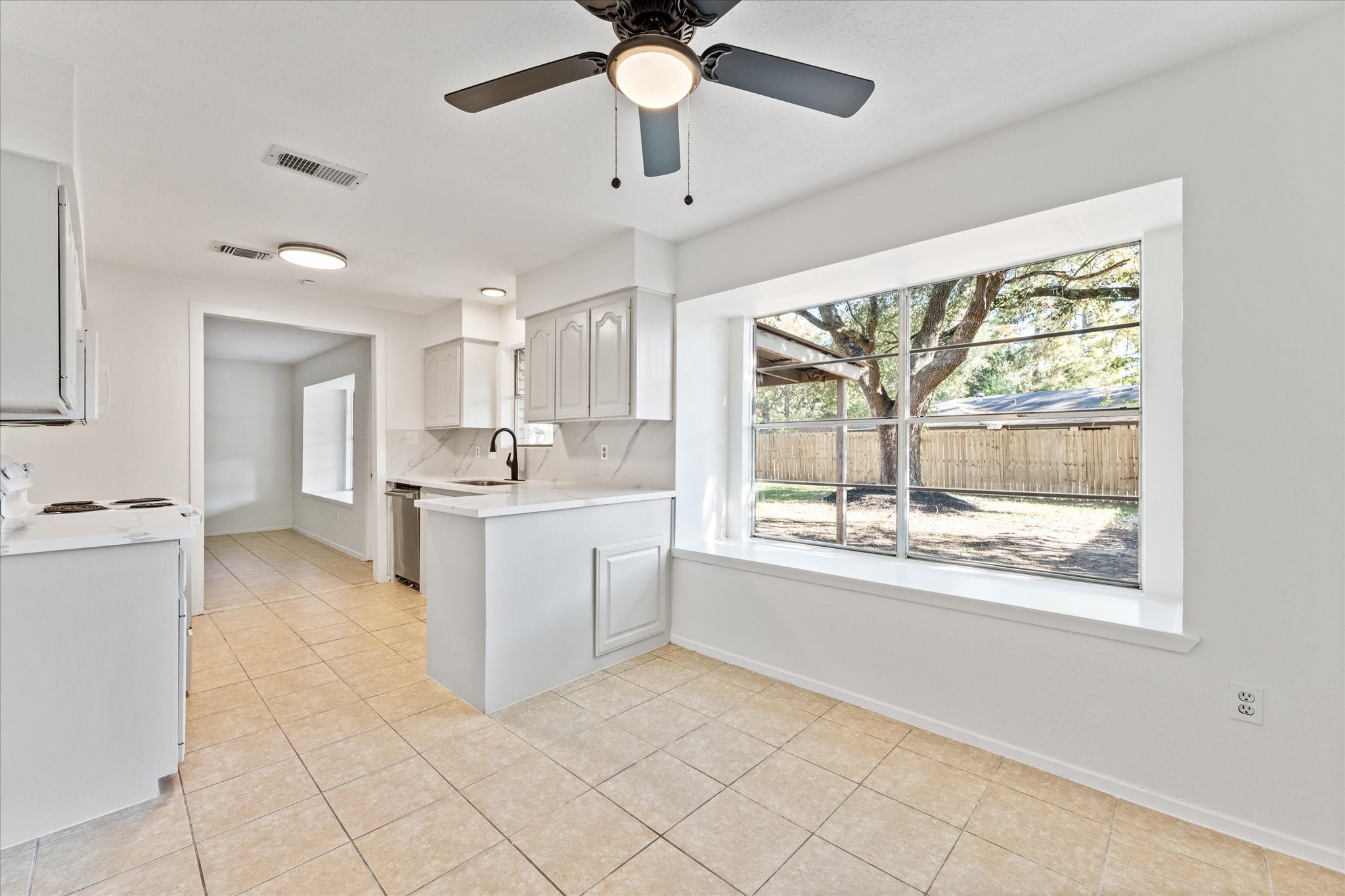 23122 Cimber Lane Spring, TX 77373 - Photo 11 of 25 a kitchen with white cabinets and a large window