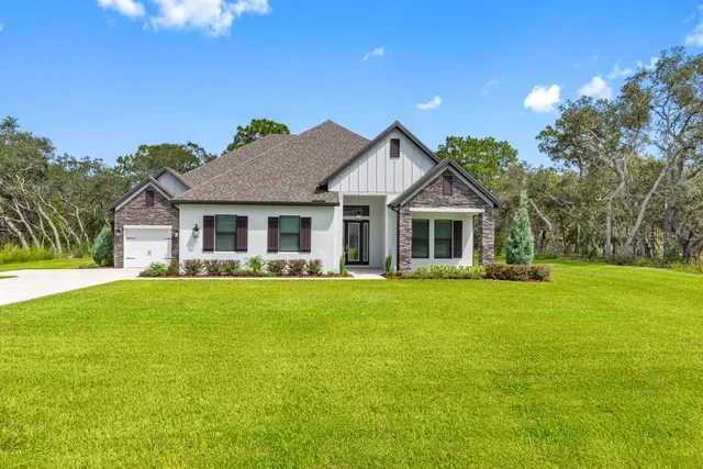 a front view of a house with a garden