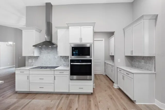a kitchen with stainless steel appliances a stove a sink and a microwave