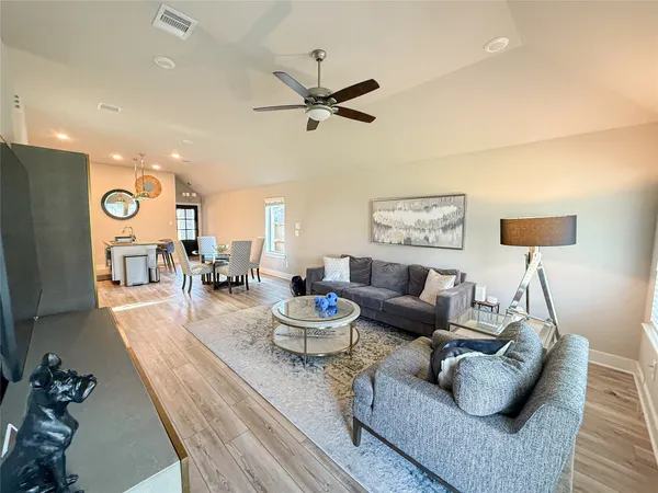a living room with furniture and a wooden floor