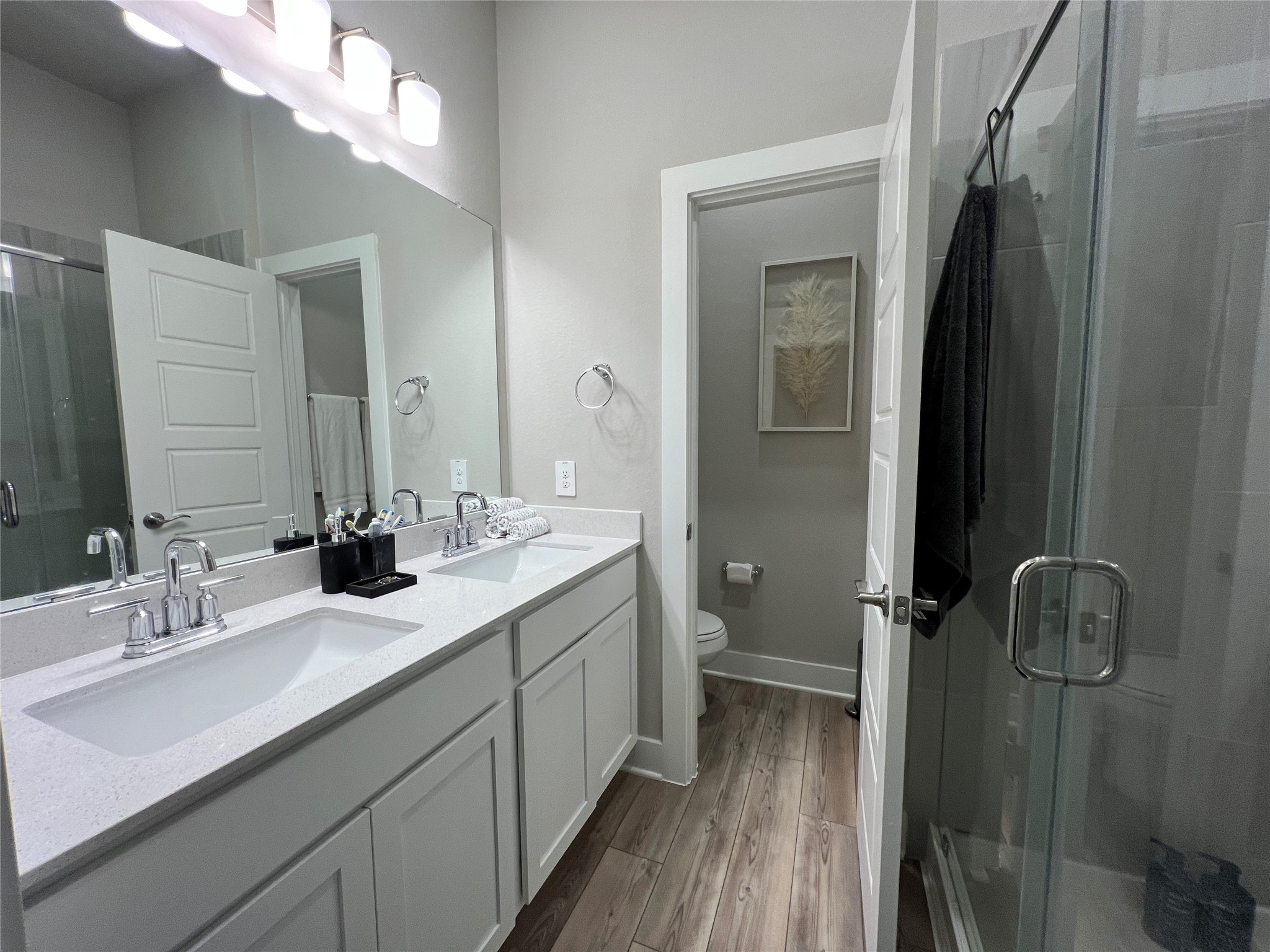 10542 Preserve Way Conroe, TX 77385 - Photo 10 of 26 a bathroom with a double vanity sink a mirror and a shower