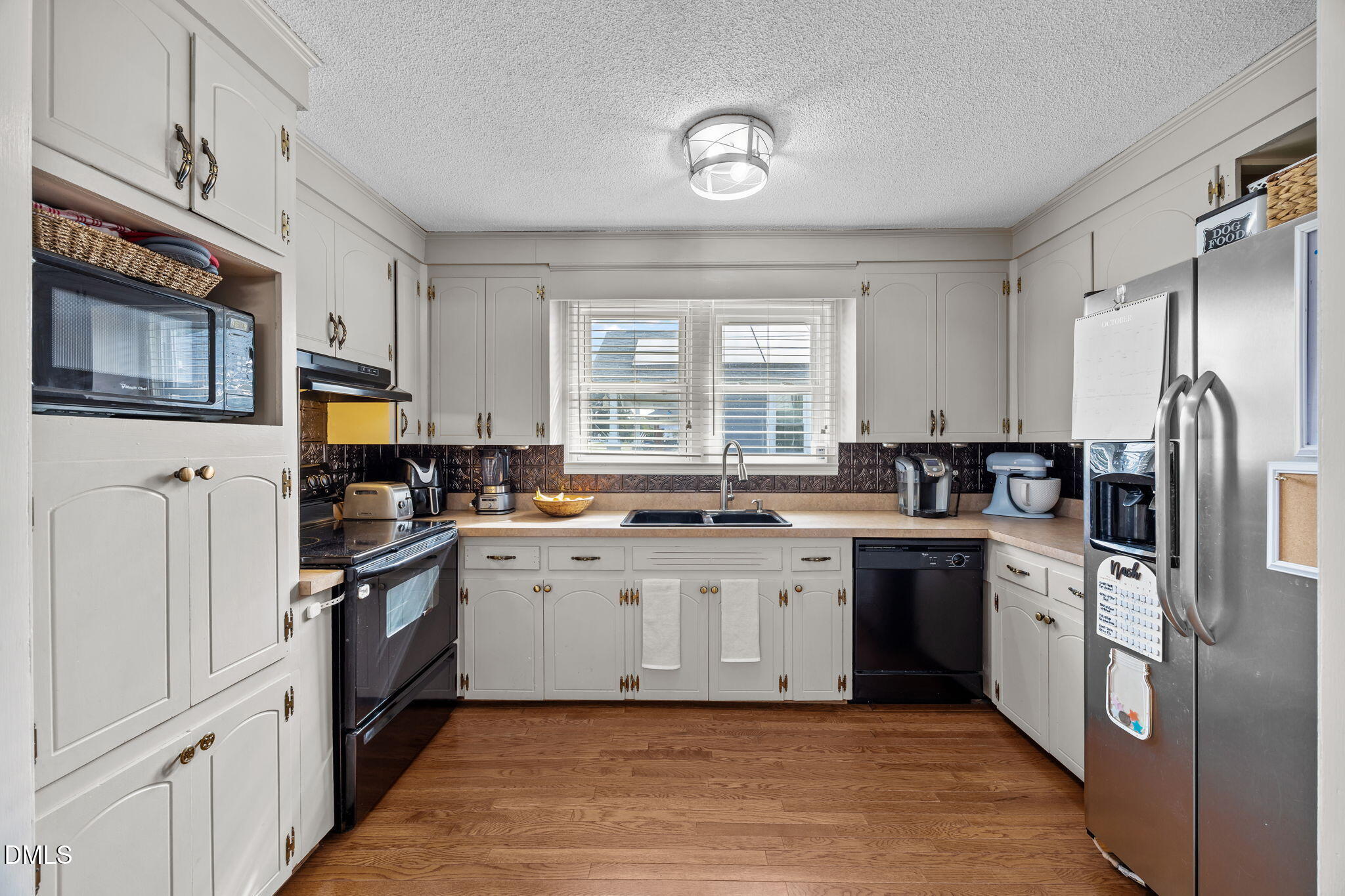 203 North 11th Street Erwin, NC 28339 - Photo 11 of 27 a kitchen with stainless steel appliances granite countertop a stove top oven a sink dishwasher a refrigerator and cabinets with wooden floor