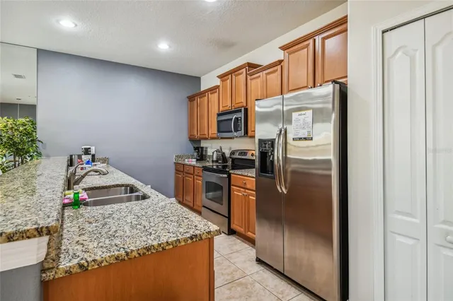 a bathroom with a granite countertop double vanity and a mirror
