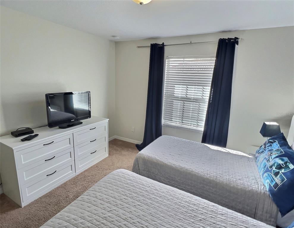 8841 Candy Palm Road Kissimmee, FL 34747 - Photo 19 of 49 a bedroom with a bed and flat screen tv
