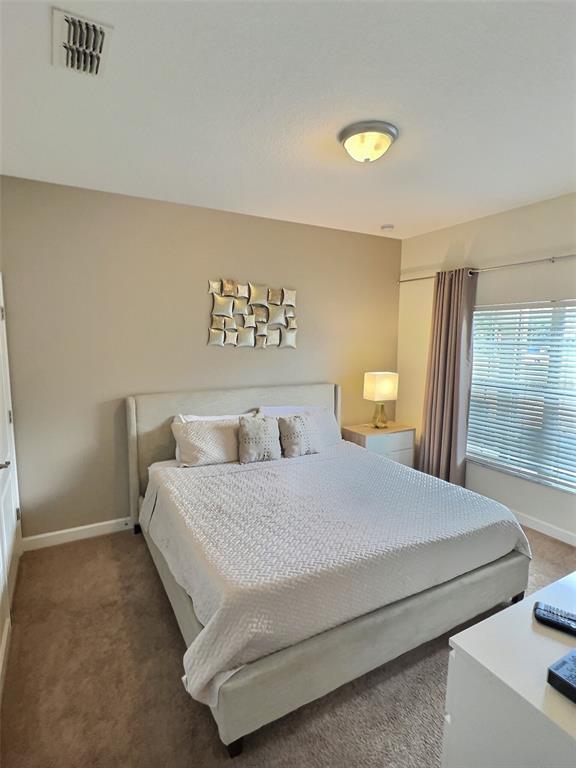 8841 Candy Palm Road Kissimmee, FL 34747 - Photo 20 of 49 a bedroom with a bed and a lamp on table