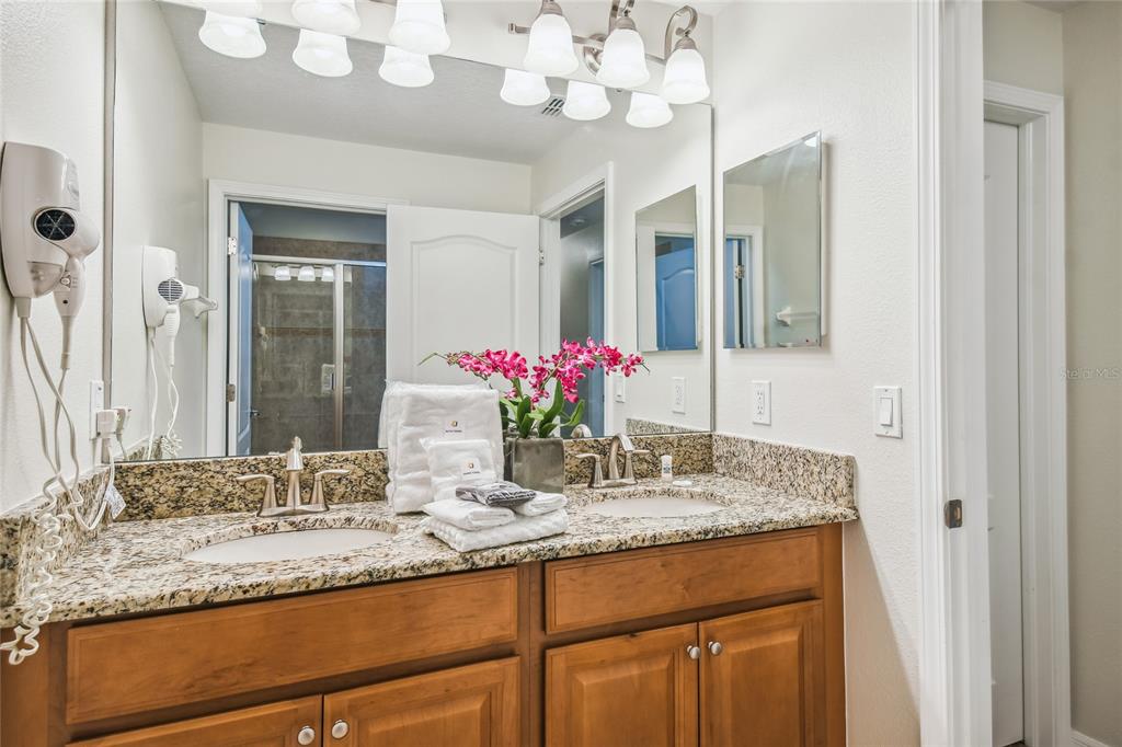 8841 Candy Palm Road Kissimmee, FL 34747 - Photo 23 of 49 a bathroom with a granite countertop double vanity and a mirror