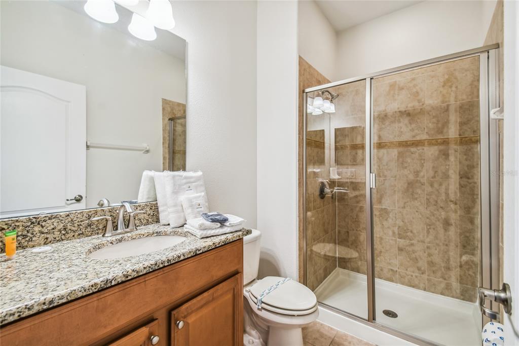 8841 Candy Palm Road Kissimmee, FL 34747 - Photo 24 of 49 a bathroom with a granite countertop sink toilet and shower