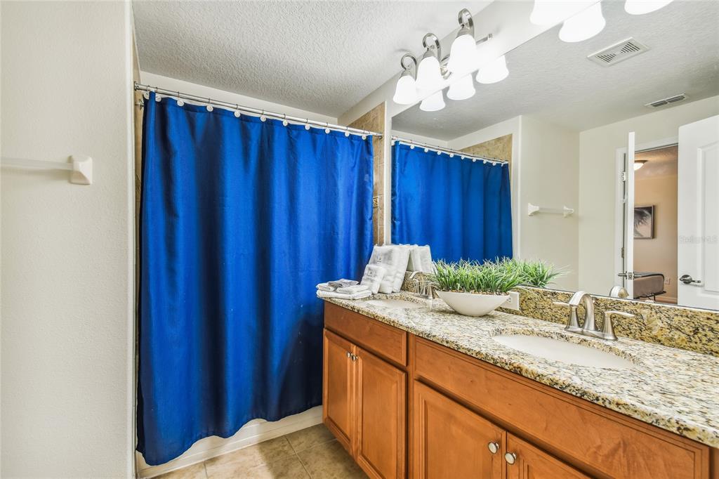 8841 Candy Palm Road Kissimmee, FL 34747 - Photo 28 of 49 a bathroom with a granite countertop sink and a mirror