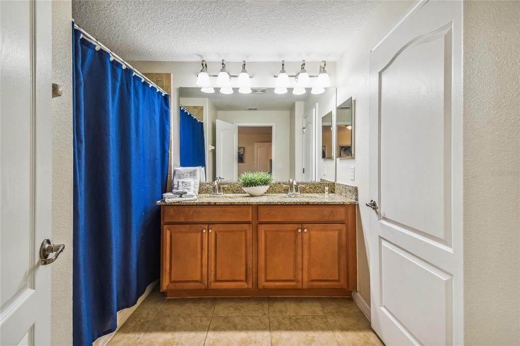 8841 Candy Palm Road Kissimmee, FL 34747 - Photo 30 of 49 a bathroom with a granite countertop sink and a mirror