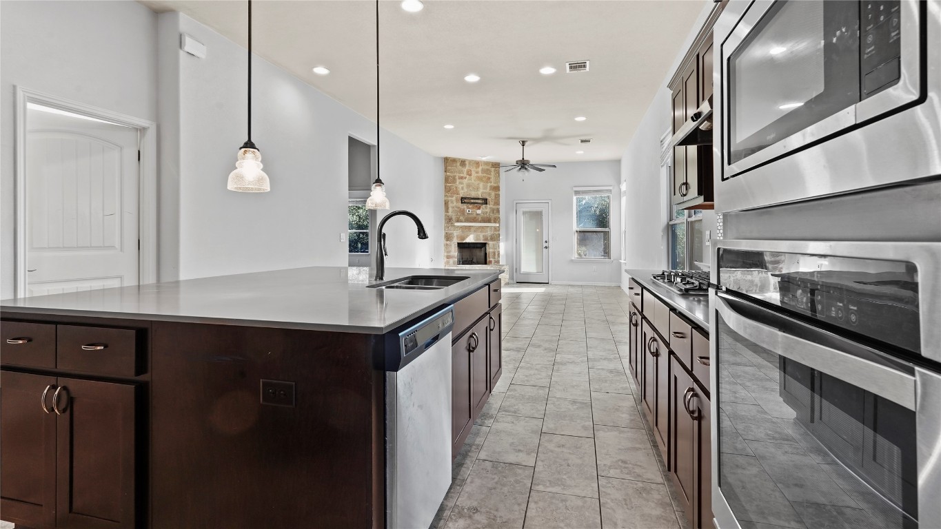 135 Simon Kyle, TX 78640 - Photo 11 of 28 a kitchen with stainless steel appliances granite countertop a sink a stove and a refrigerator