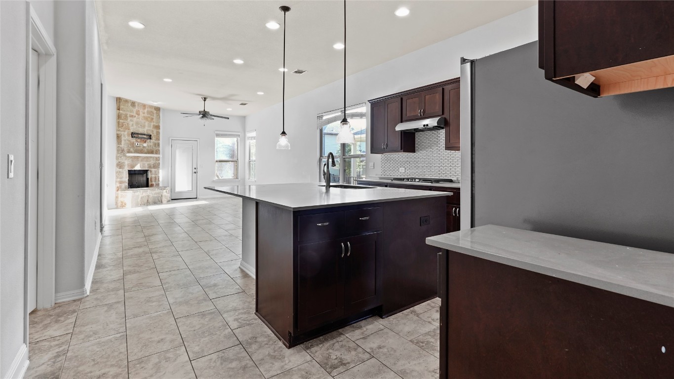 135 Simon Kyle, TX 78640 - Photo 6 of 28 a kitchen with kitchen island a sink stainless steel appliances and a counter top