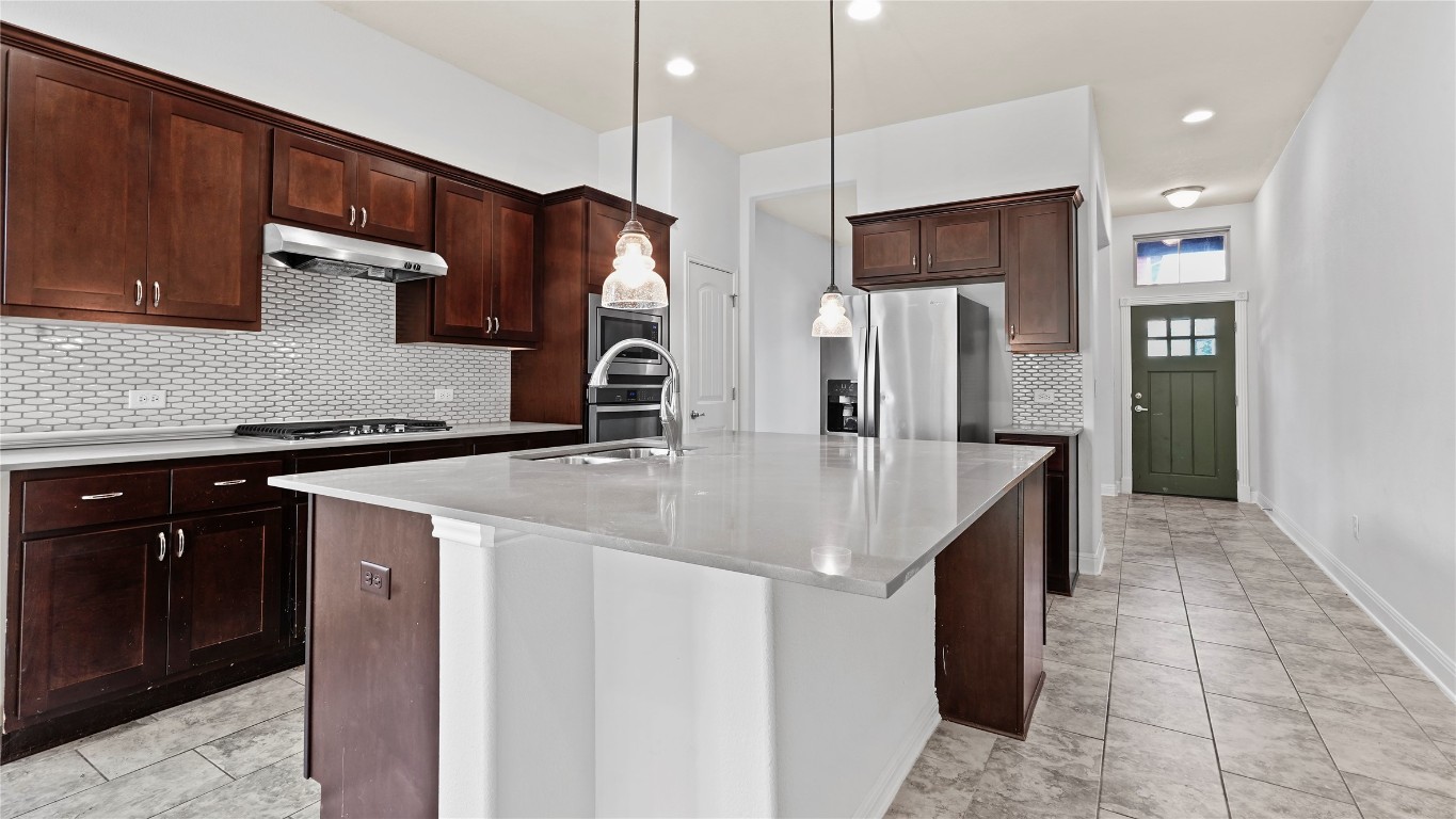 135 Simon Kyle, TX 78640 - Photo 7 of 28 a kitchen with stainless steel appliances granite countertop a sink a stove and a refrigerator