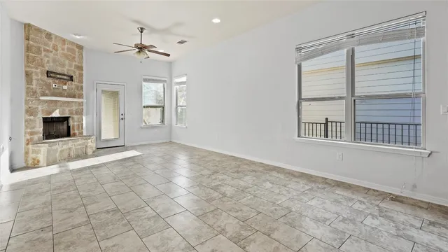 an empty room with kitchen and chandelier fan