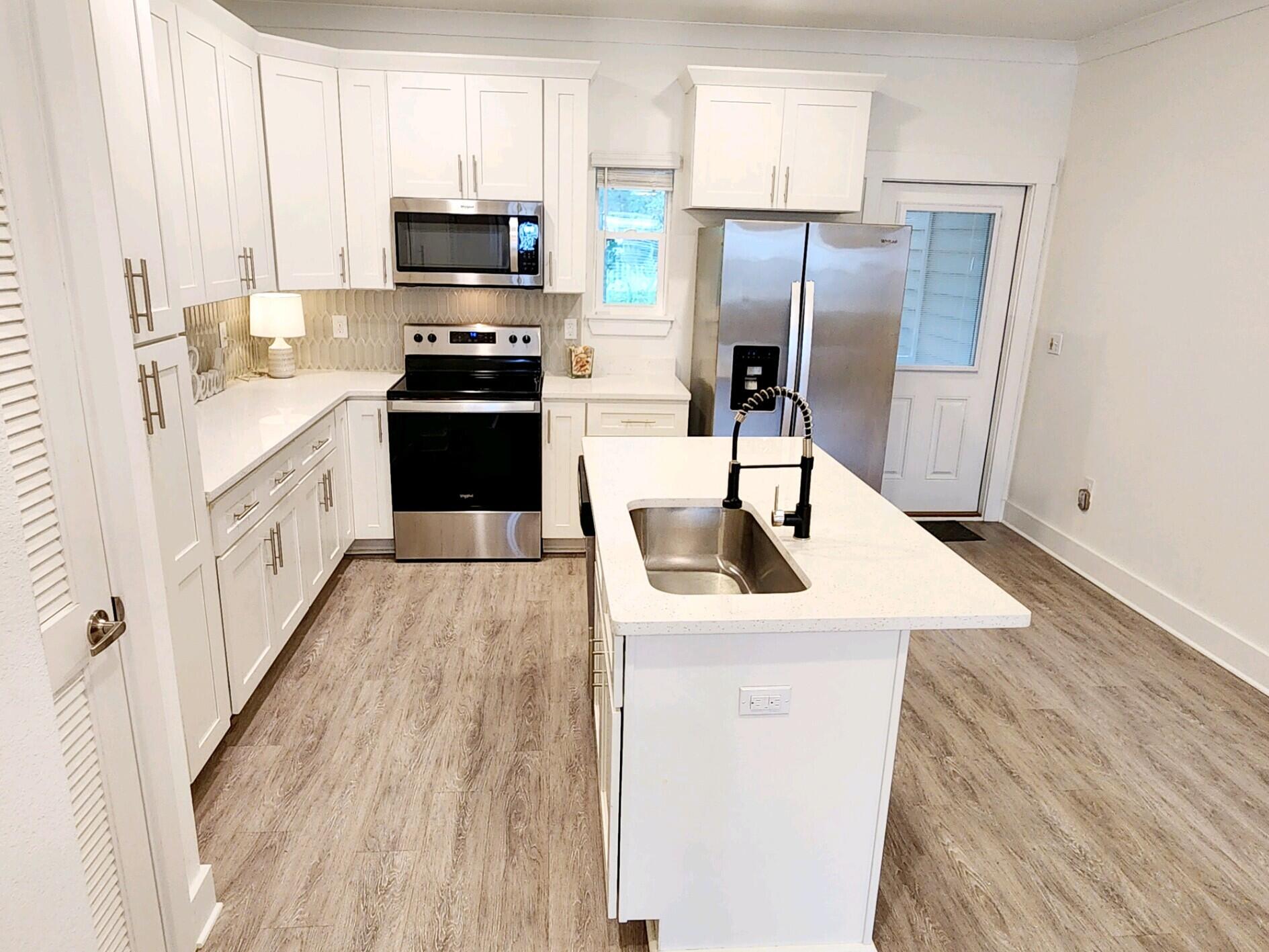 266 North Sand Palm Road Freeport, FL 32439 - Photo 10 of 34 a kitchen with a sink a microwave a refrigerator and cabinets