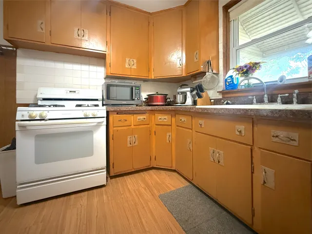 a kitchen with a stove sink and cabinets