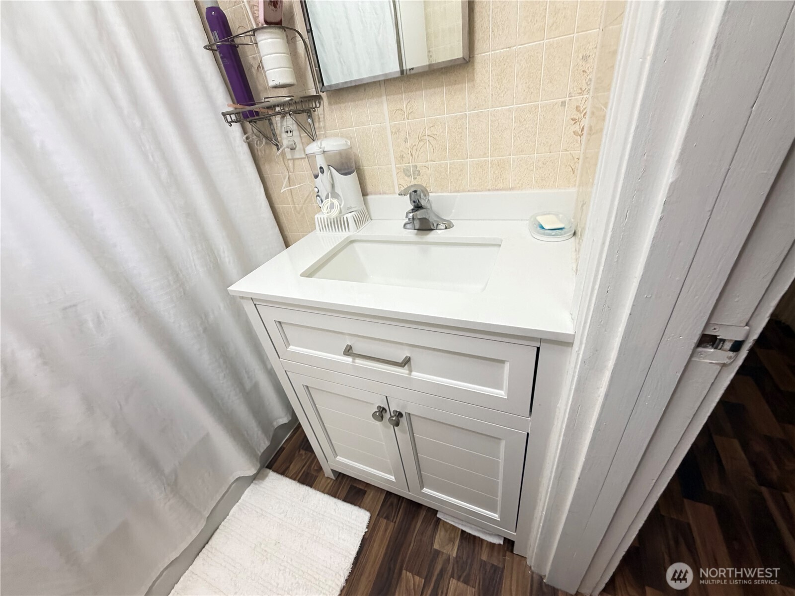 409 Birch Street South Omak, WA 98841 - Photo 18 of 32 a bathroom with a sink a toilet and shower curtain