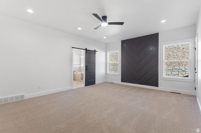 638 East Mountain Road North Ogden, UT 84414 - Photo 12 of 28 Unfurnished bedroom featuring a barn door, ensuite bath, light carpet, a ceiling fan, and recessed lighting
