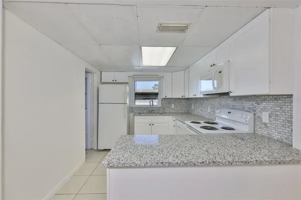 a kitchen with stainless steel appliances granite countertop a sink refrigerator and cabinets