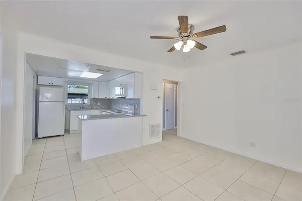 a kitchen with a refrigerator a sink cabinets and a window