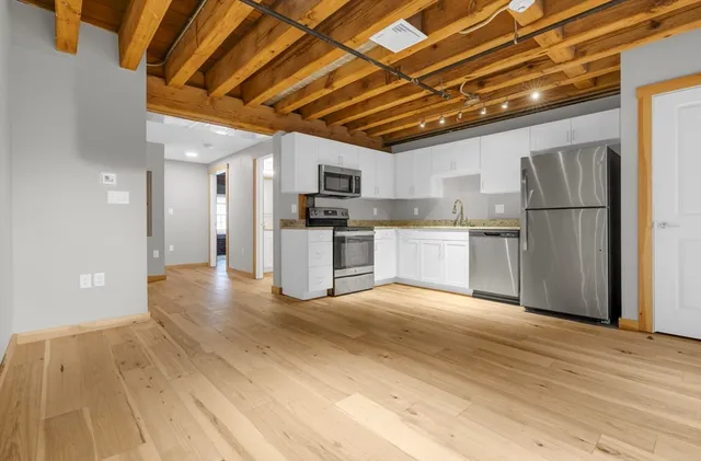 a view of a kitchen with a sink and a refrigerator