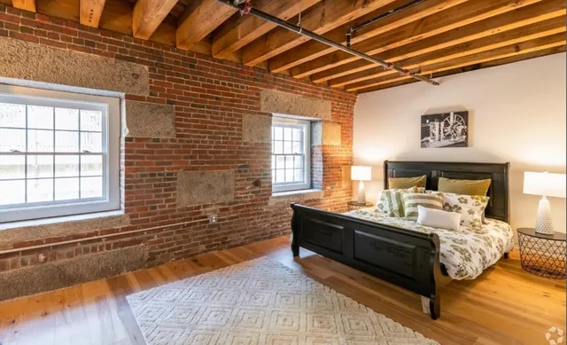 a bed sitting in a bedroom next to a window