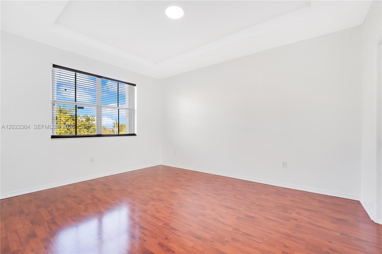27433 Southwest 137th Court, Unit 1 Homestead, FL 33032 - Photo 16 of 28 an empty room with wooden floor and windows