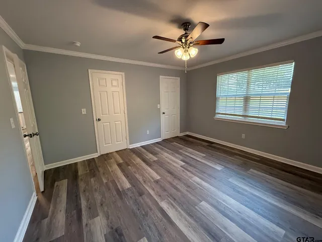 a view of a hallway with wooden floor and staircase