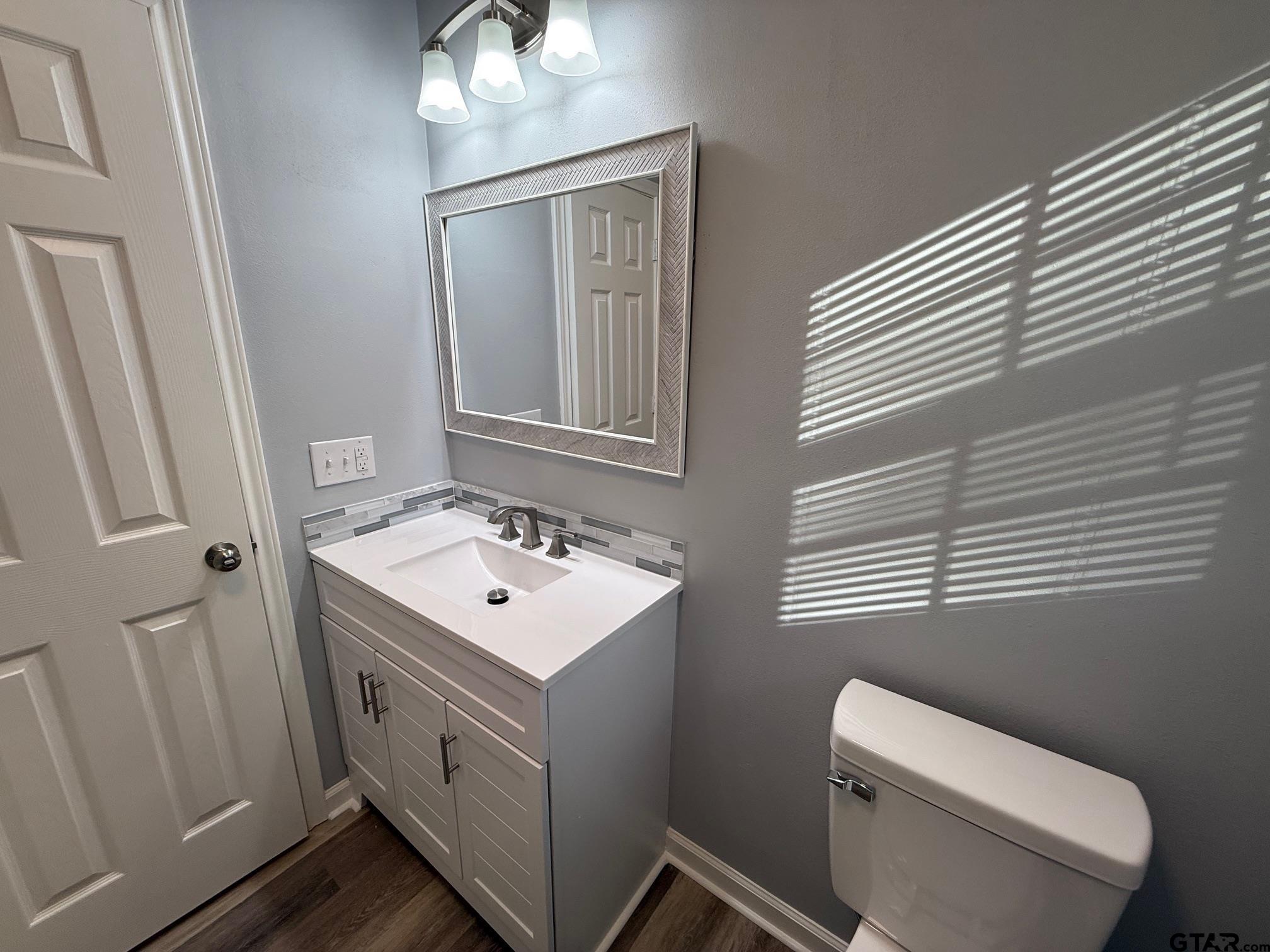 3248 Highway 79 Henderson, TX 75652 - Photo 28 of 44 a bathroom with a toilet sink and mirror