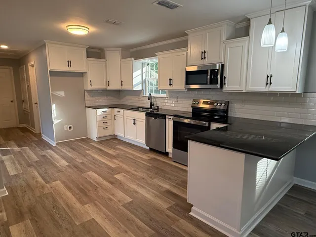 a kitchen with stainless steel appliances granite countertop a sink and a stove