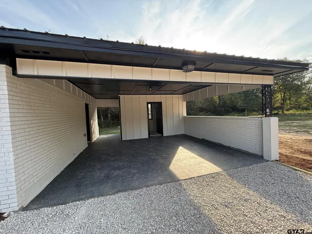 a view of a house with wooden deck and trees