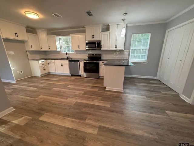 a large kitchen with stainless steel appliances granite countertop a stove and a sink