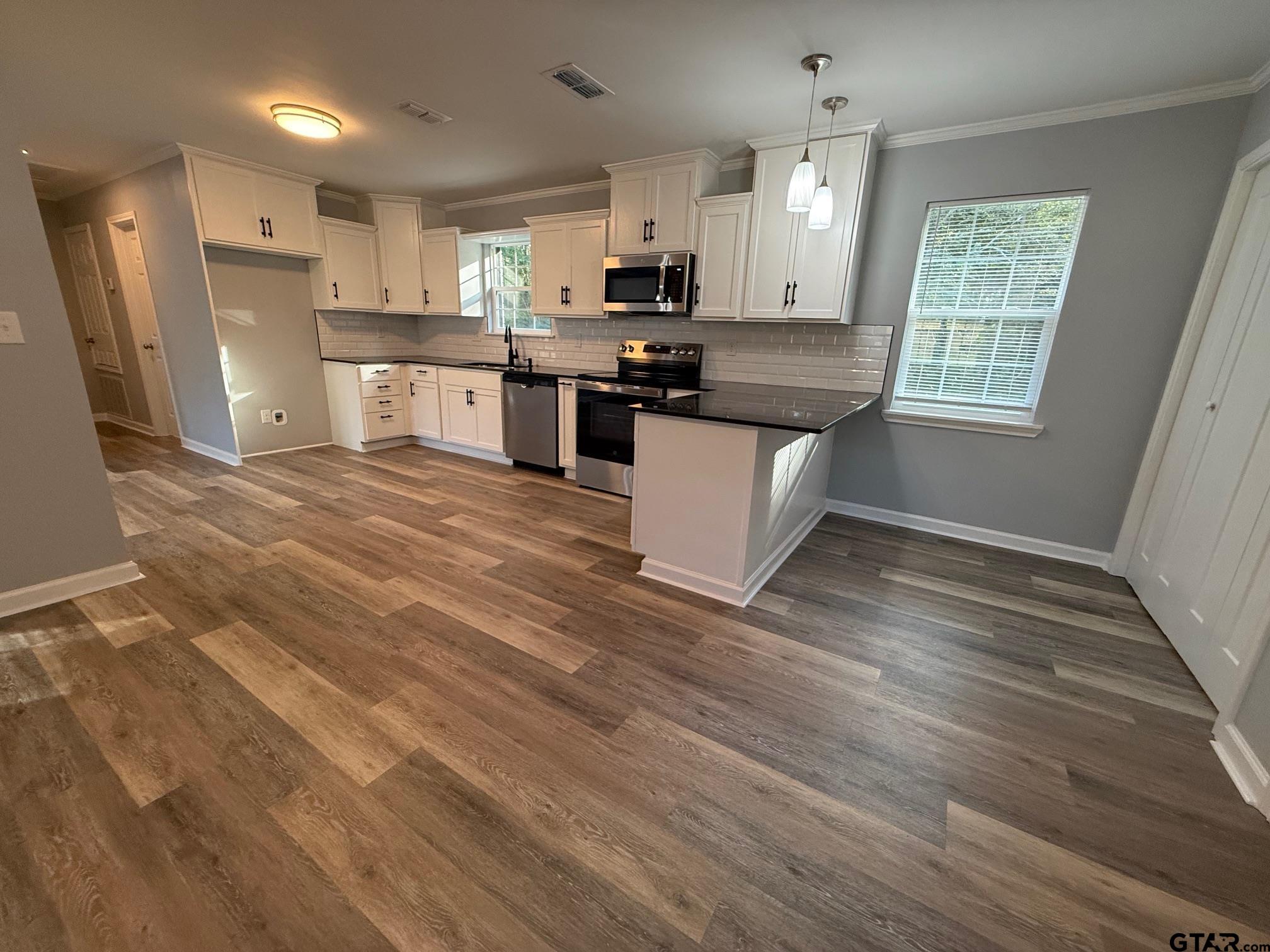3248 Highway 79 Henderson, TX 75652 - Photo 6 of 44 a kitchen with stainless steel appliances granite countertop a stove a sink a refrigerator white cabinets and wooden floor