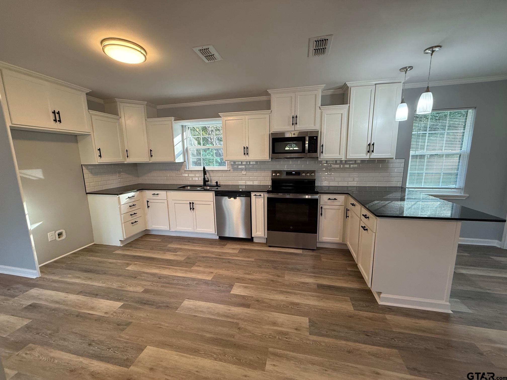 3248 Highway 79 Henderson, TX 75652 - Photo 7 of 44 a large kitchen with stainless steel appliances granite countertop a stove a sink dishwasher and a refrigerator