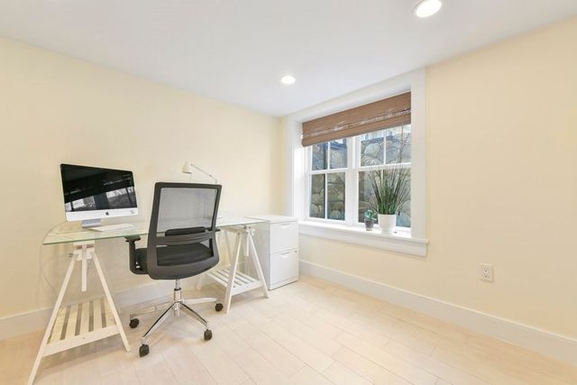 a view of a workspace with furniture and a window