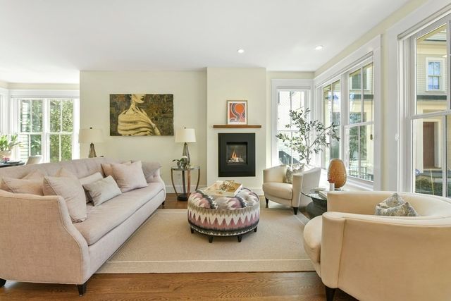 a living room with furniture a fireplace and a large window