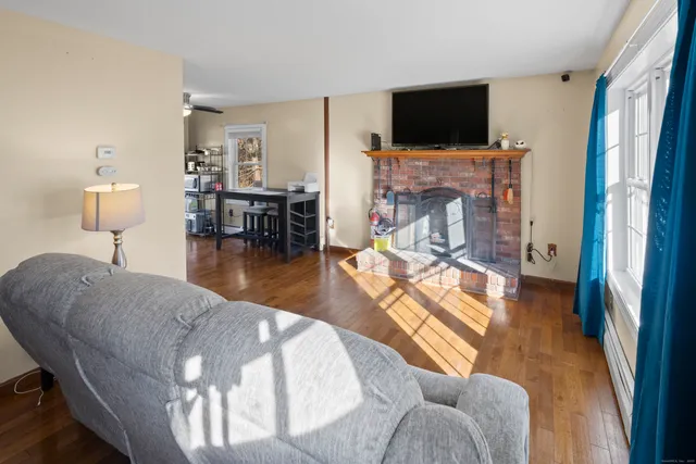 a living room with furniture a flat screen tv and a fireplace