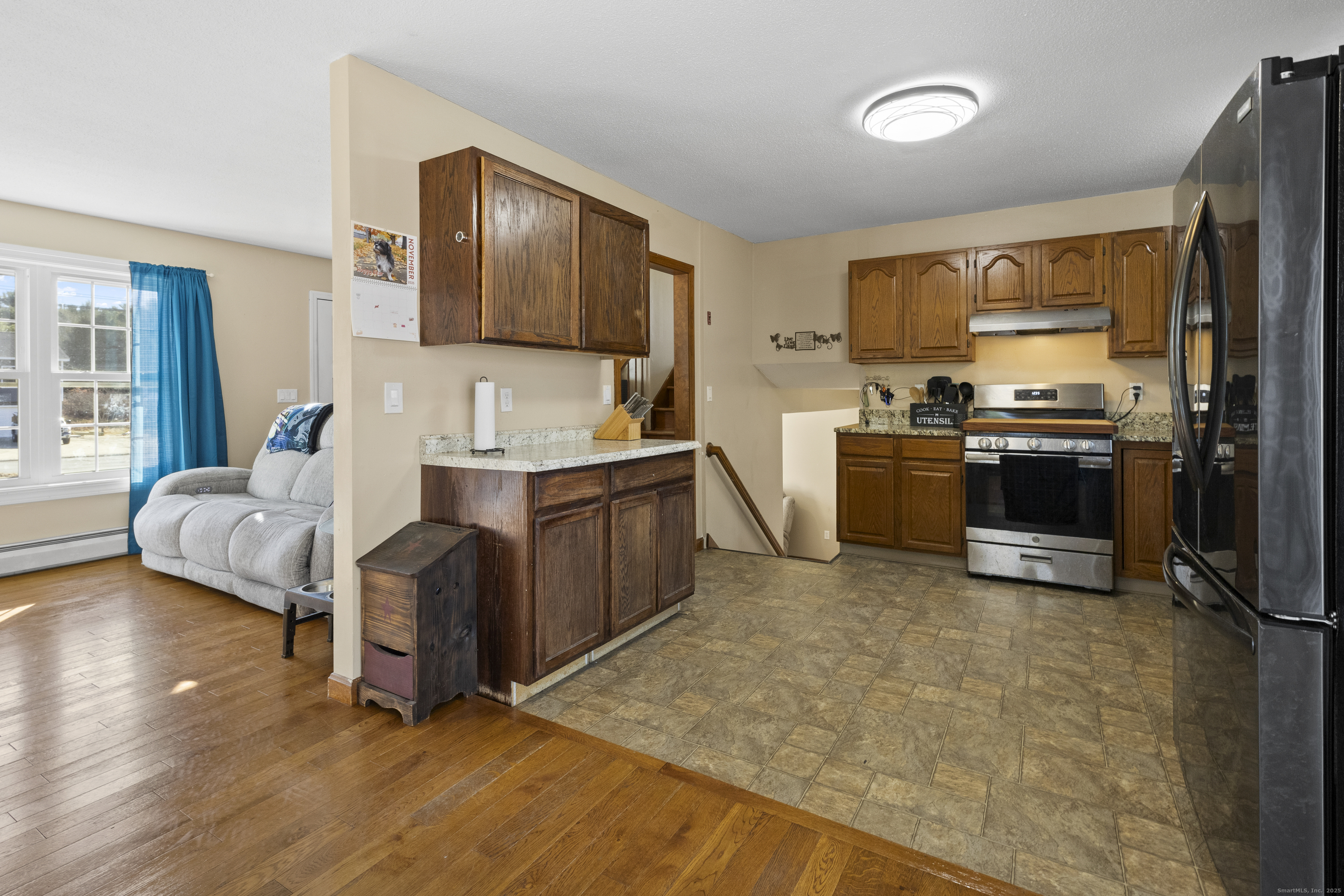 230 Cemetery Road Plainfield, CT 06374 - Photo 8 of 29 a kitchen with stainless steel appliances granite countertop a refrigerator a stove and a sink with wooden floor