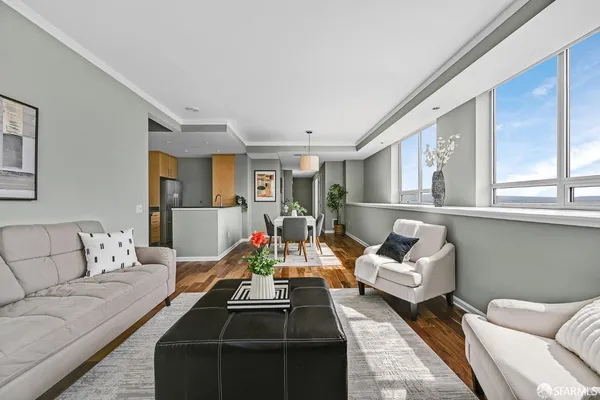 a living room with furniture and a view of kitchen